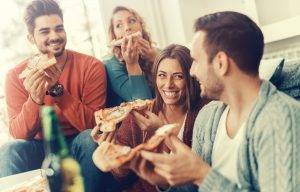 Two young couples enjoying pizza