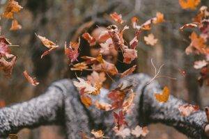 Woman throwing leaves into the air