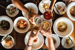 Overview of 4 people clinging glasses over dinner