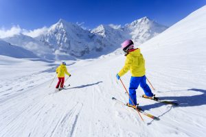 Two people skiing down mountain