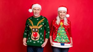 An elderly couple holding their jumpers