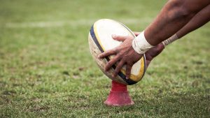 Rugby player placing the ball on a cone